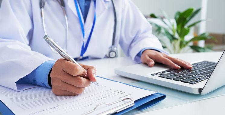 Physician at desk with computer