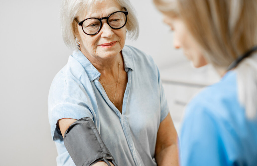 Senior woman with a physician getting her blood pressure checked
