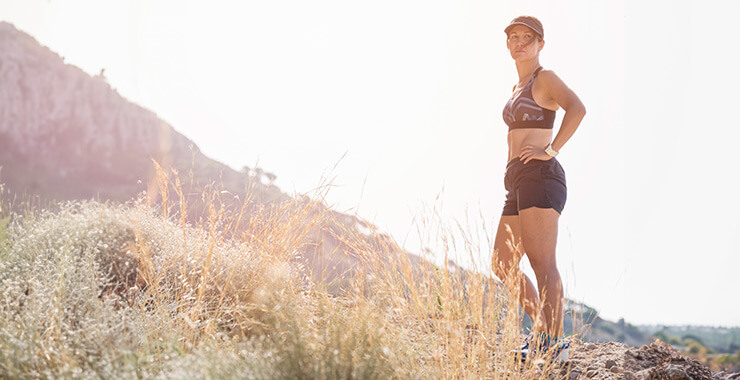 Woman who has been jogging stops for a rest in the desert