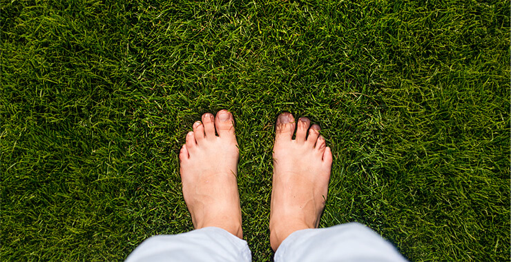 Bare feet grounding in green grass